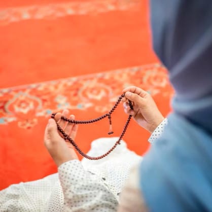 namaz kilan biri tesbih ile dua ediyor